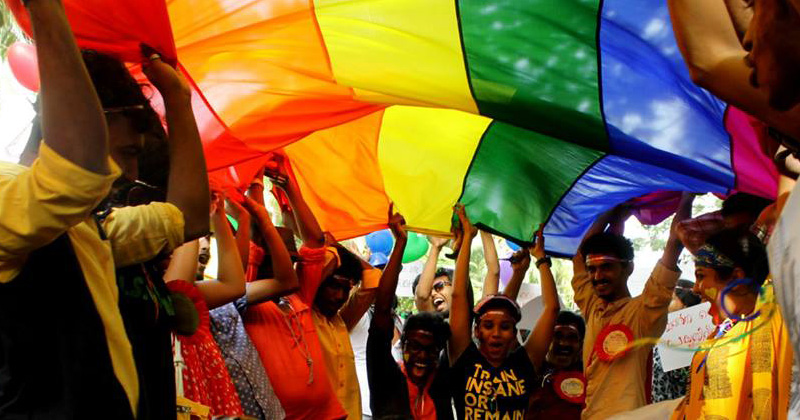 ragazzi indiani manifestano per i diritti degli LTBS sotto una bandiera arcobaleno